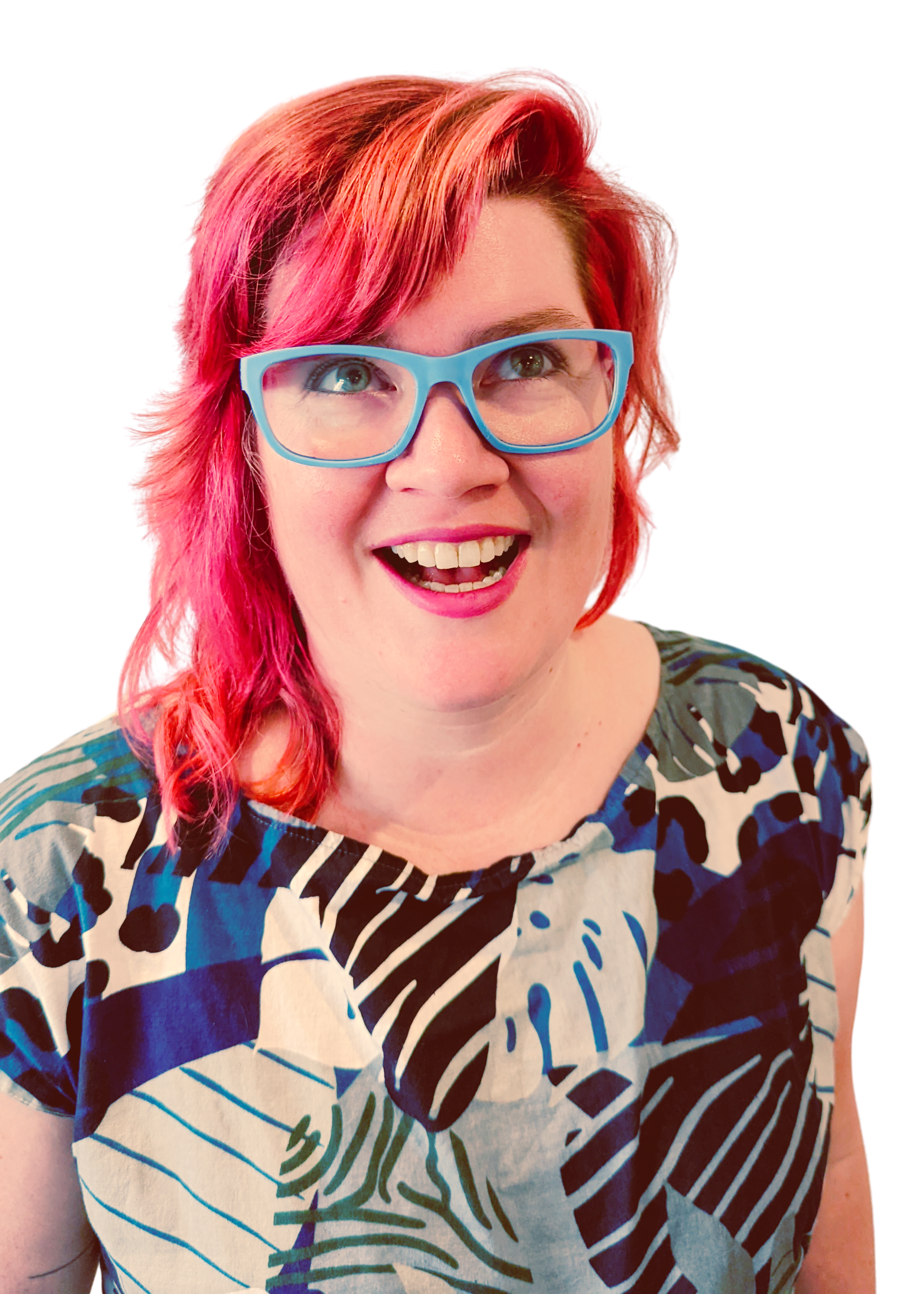 A photo of Amanda. She has bright red hair, blue glasses, and wearing a jungle patterned jumpsuit. She is smiling and looking upward
